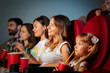 © fotofabrika - Group of friends sitting in movie theater with popcorn and drinks