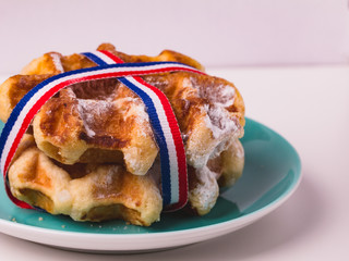 Wall Mural - Belgian waffles with sugar powder, served on  turquoise plate, close-up