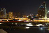 Fototapeta  - Night view of the center of Baku. The movement of cars through the night city. Skyscrapers, high-rise buildings and automobile interchanges. Republic of Azerbaijan