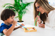 © Microgen - Child psychology, little boy blowing beads with straw