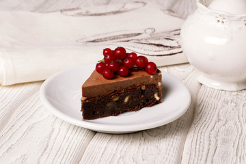 Wall Mural - Delicious chocolate cake in white plate on wooden table background, closeup