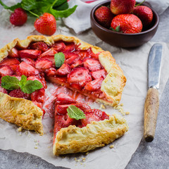 Wall Mural - Galette with strawberry on the gray concrete stone background. Vegetarian healthy berry tart. Delicious summer food dessert.