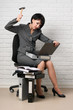 © soleg - angry business woman with laptop and folders having stress, dressed in a gray suit poses in front of a white wall