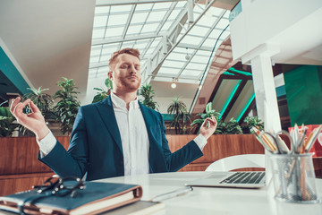 Wall Mural - Worker man meditating at desk in office.