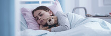 Panorama Portrait Of A Sick Little Girl Sleeping In A Hospital Bed With A Teddy Bear - View Through The Glass Door