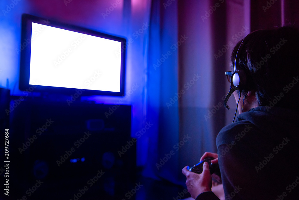 Young Male Gamer With Glasses And Headset Playing Video Game