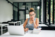 © bnenin - Portrait of charming young female student sitting in modern library.