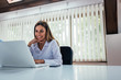 © bnenin - Low angle image of smiling businesswoman using laptop.