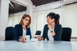 © bnenin - Two business woman talking while sitting in the office.