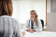 © bnenin - Beautiful female doctor laughing while talking to a patient.