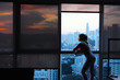 Young Woman Looking At Urban Landscape Out Of Window