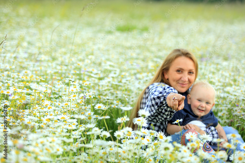 Matka z córką bawią się na łące pełnej kwiatów. - obrazy, fototapety, plakaty 