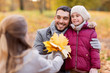 © Syda Productions - family, season and people concept - happy mother, father and little daughter with maple leaves at autumn park