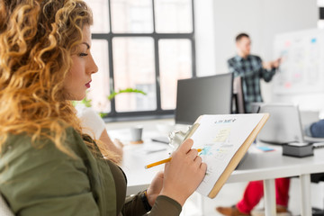 Wall Mural - business, user interface design and people concept - creative woman with sketch on clipboard at offi