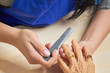 © DenisProduction.com - Manicurist filing nails to senior woman. Old woman hands in a nail salon receiving a manicure by a beautician with nail file. Elderly woman is getting a manicure in beauty salon.