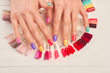 Wall Mural - Hands with summer multicolored nails. Samples of various hand painted fingernail designs and manicured hands. Stylish summer manicure.