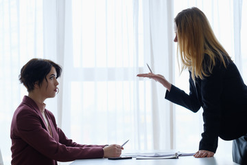 Wall Mural - boss reproaching her employee. business woman getting a reprimand or reproof chief manager. superior and subordinate professional relationship.