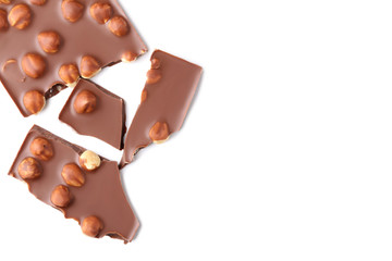 Chocolate pieces with hazelnuts on white background