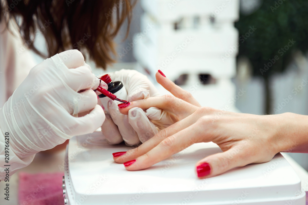 Young woman doing manicure in salon. Beauty concept. - obrazy, fototapety, plakaty 