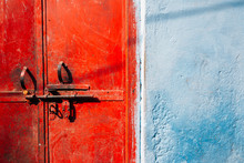 Old Rusty Red Metal Door And Blue Wall