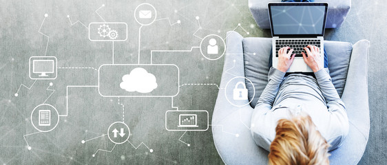 Wall Mural - Cloud Computing with man using a laptop in a modern gray chair