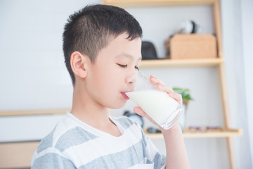 Young asian boy drinking a glass of milk for breakfast