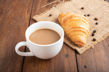 Wall Mural - Coffee and croissant on wooden background