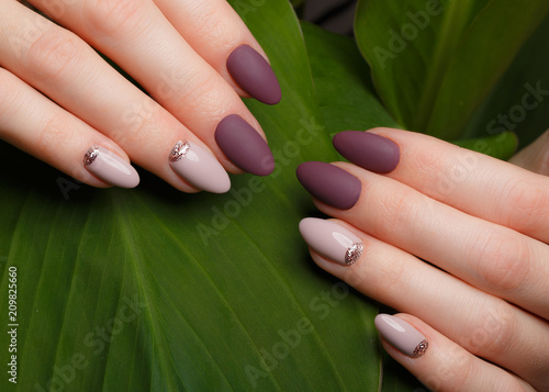 Ταπετσαρία τοιχογραφία Tender neat manicure on female hands on a background of green leaves