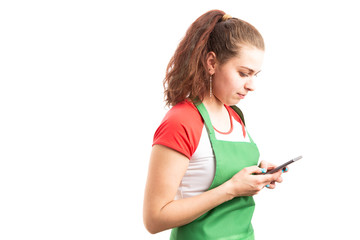 Wall Mural -  Female supermarket or hypermarket employee texting on smartphone.