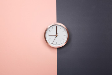 Rose gold clock on pastel pink and grey background. minimal idea business concept.