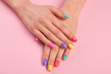 Female Hands With Colorful Polish Nails. Woman Well-groomed Hands With Multicolor Nails On Salon Table. Manicure Nail Painting.
