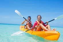 Happy Girl And Her Father Kayaking At Tropical Sea On Yellow Kayak