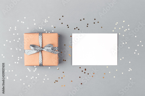 Gift box wrapped in kraft paper and tied with gray ribbon and white blank on ...