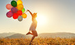 canvas print picture - happy woman with balloons at sunset in summer