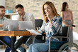 © Africa Studio - Young woman in wheelchair and colleagues at workplace
