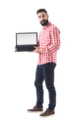 Poster - Cool bearded hipster guy in smart casual clothes showing blank laptop monitor. Full length isolated on white background. 