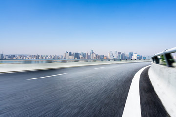 asphalt road with city skyline