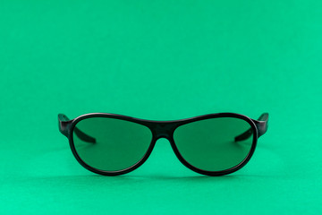 Modern fashion and office glasses isolated on green background