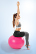 Pilates and fitness sport girl in yoga fitness exercise on the floor, indoor training sitting on the pink pilates ball. Healthy lifestyle. Yoga position
