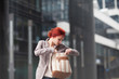© Kanea - young beautiful business woman holding purse, working in downtown, outdoors