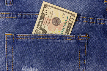 Ten dollars banknote in the pocket of blue jeans