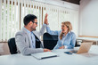 © bnenin - Successful business colleagues giving high five in office.