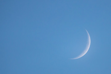 new moon in the daytime on the day blue sky