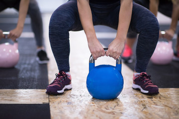 Wall Mural - athletes doing exercises with kettlebells