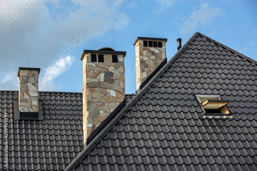 Cuadros en Lienzo Log house in the mountains with a roof made of tiles and stone chimneys