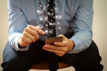 close up of businessman working with mobile phone and sitting on the chair in modern office