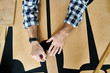Crop shot from above of casual man transferring drawing patterns on black fabric working in studio. 
