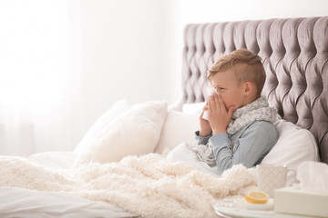 Wall Mural - Sick little boy with tissue suffering from cold in bed