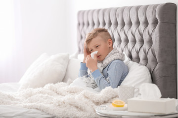 Wall Mural - Sick little boy with tissue suffering from cold in bed