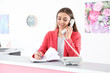 © New Africa - Beauty salon receptionist talking on phone at desk